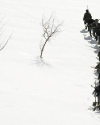 Black and white image of people walking in snow